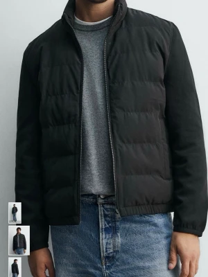 Svart pufferjacka med dragkedja - Stilren svart pufferjacka med hög krage och hel dragkedja framtill. Jackan har en quiltad design och raka ärmar, perfekt för kyliga dagar. Passar till jeans och hoodie för en avslappnad look.