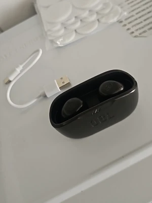 Svarta trådlösa in-ear JBL hörlurar - Säljer ett par svarta trådlösa in-ear hörlurar från JBL med laddningsetui och USB-laddkabel. Snygg och kompakt design som är enkel att ta med sig. Perfekt för musik, poddar eller samtal på språng.