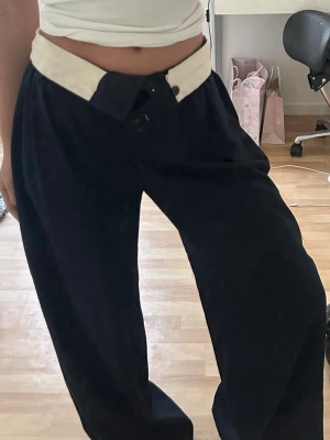  mörkblåa byxor med hög midja - Hej! Säljer ett par mörkblåa byxor med lös passform och hög midja. Byxorna har bred linning och veck framtill för en trendig look. Perfekta för dig som gillar en avslappnad men ändå stilren stil.