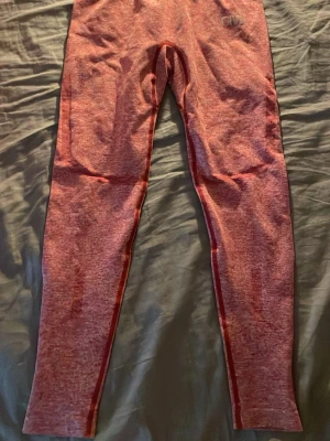 ICIW träningsbyxor  - Ett par fina röda träningsbyxor som sitter tajt. Dom är ganska högmidjade men kanten går att vika ner så dom blir som lågmidjade. Storleken står inte på dom men de passar på dom som har XS och även S.