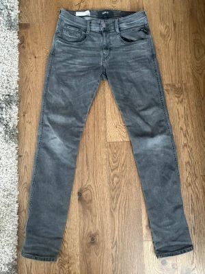 Replay anbass jeans hyperflex Svart/Grå  - Snygga svart gråa jeans från Replay med smal passform och klassisk femficksdesign. W29 L32. Jeansen har diskreta slitningar och detaljerade sömmar på bakfickorna. Tillverkade i mjukt denimtyg som ger en bekväm känsla och stilren look. Hyperflex 🤩⭐️ (Inga hål eller defekter) Fri frakt 🚚 