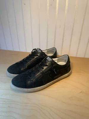 Golden Goose skor svarta - Säljer ett par snygga golden goose skor. Dem är i materialet läder och mocka mm. Dem är i skick 10/10. Säljer dem på grund av att dem är för små för mig, och jag kunde inte returerna dem. Är öppen för alla frågor och pris kan diskuteras!