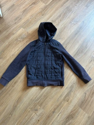 Ralph lauren cardigan - Snygg mörkblå cardigan från ralph lauren med dragkedja och quiltad framsida. Ärmar och baksida i mjukt tyg, medan framsidan har ett vadderat mönster. Perfekt för lager-på-lager och chill vardagsstil. Huva för extra komfort och stil. Sällsynt då den slutat tillverkas.