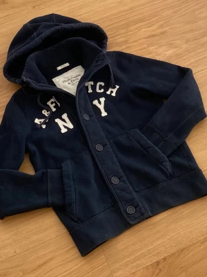 Abercrombie & Fitch cardigan  - Säljer en roligt snygg Abercrombie & fitch cardigan. Skicket är 8/10. Storlek M. Priset kommer ligga på 899kr.