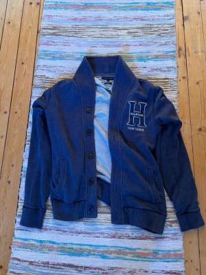 Mörkblå kofta från Hilfiger - Säljer en vintage Tommy hilfiger kofta. Riktigt stilig tröja som passar till finare tillfällen.