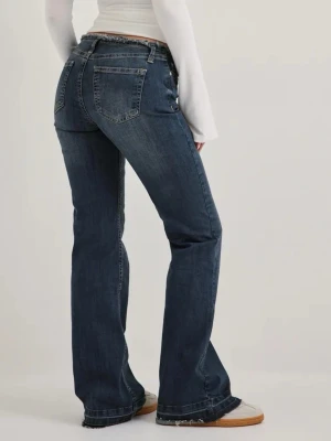 Mörkblå bootcut jeans med rå kant - Säljer ett par mörkblå bootcut jeans med rå, fransad kant nedtill. Jeansen har klassisk femficksdesign. Materialet är denim med lätt stretch för skön passform. Perfekta för en avslappnad och trendig look. Säljer dessa för dem inte används och tar bara plats i garderoben. Kostar 599kr på Nellys hemsida. 💕😊 Använts få gånger 