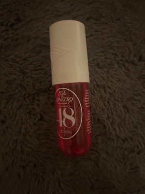 Sol de Janeiro 48 Parfym Mist - Fräsch body mist från Sol de Janeiro med doften 48. Flaskan är cylinderformad med en klar rödrosa botten och vit kork. Perfekt för dig som gillar söta och tropiska dofter. Enkel att ta med i väskan tack vare smidig storlek.