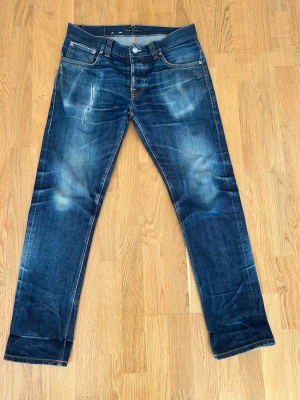 Nudie grim Tim selvedge - Ett sjukt par grim tim selvedge som har superfina fades och lagningar. De är storlek 32/32 men utgå från måtten  Totallängd: 101 cm Midja tvärsöver: 43 cm Benöppning: 18 cm