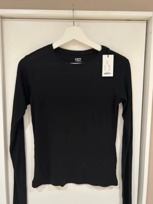 Svart långärmad tröja - En enkel och stilren svart långärmad topp från 157. 