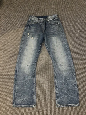 Straight bootcut jeans - Säljer ett par blå jeans med raka bootcut jeansen från peaces of life studio på grund av att de var lite för små. Jeansen har en tvättad look med ljusa partier och klassiska fem fickor. passformen är avslappnad. 