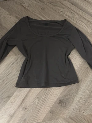 Mörkgrön långärmad topp - En stilren mörkgrön långärmad topp med rundad urringning. Toppen har en figurnära passform och är tillverkad i ett mjukt bomullsmaterial. Perfekt att matcha med jeans eller kjol för en enkel och snygg look.