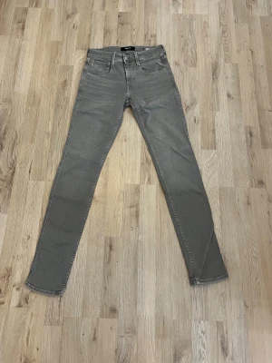 Gråa jeans Replay - Snygga gråa slim fit jeans från Replay i modellen anbass med klassisk femficksdesign. Tillverkade i ett mjukt denim-material som ger en skön passform. Perfekta för dig som gillar stilrena och moderna jeans. Pris ej hugget i sten och hör av dig vid frågor!
