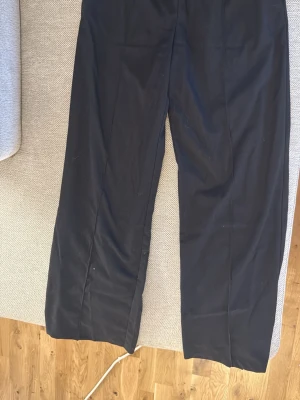 Svarta raka kostymbyxor - Säljer ett par klassiska svarta kostymbyxor med rak passform och pressveck. Dom är gjorda av yttertyg 67%, polyester 31% och viskos 2%