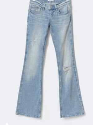 Ljusblå bootcut jeans med slitningar - Säljer ett par ljusblå bootcut jeans med slitna detaljer på låret och knät. Jeansen har klassisk femficksmodell, hög midja och är tillverkade i mjuk denim. Perfekta för en avslappnad och trendig look.