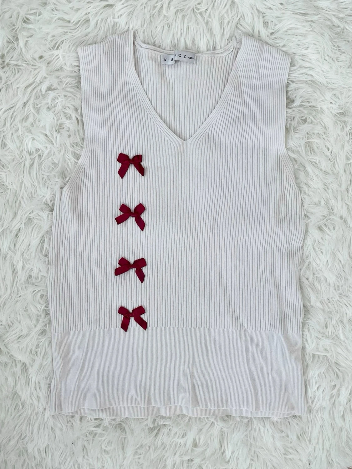 Vit ribbad topp med röda rosetter