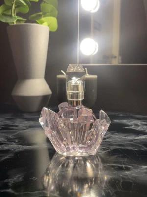 Ariana Grande R.E.M parfym. - Säljer en Ariana Grande parfym i en ljusrosa, kristallformad glasflaska. Luktar femenimt, lavendel och passar till alla tillfällen 💜