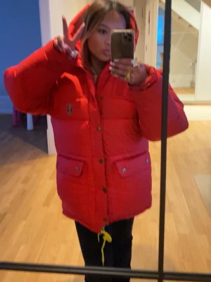 Röd dunjacka från Fjällräven - Snygg röd dunjacka från Fjällräven med huva och stora fickor framtill. Jättefin Fjällräven jacka super skön, tål kylan upp till 35-, jag älskar den! Den är lite förstår för mig, byte går också bra. Priset går att diskuteras