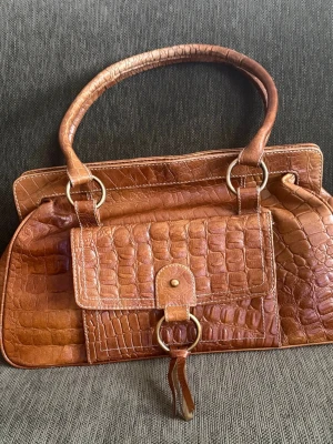 Skinnväska  vintagestil - Väska I crocopräglat skinn . Klassisk modell , mycket rymlig .  34*22 cm