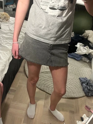 Grå jeanskjol  - Säljer en snygg grå jeanskjol i kort modell med rå, fransig kant nertill. Kjolen har klassiska jeanssömmar och fickor både fram och bak. Perfekt till en avslappnad och trendig look. Säljer den då den inte riktigt passar mig och inte kommer till användning längre, kontakta mig om ni har några frågor💕