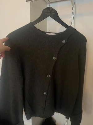 Mörkgrön stickad tröja  - Mysig fin mörkgrön stickad tröja med knappar på. Ser inte så grön ut på kameran men är det i verkligheten. Oanvänd och köptes för 300 kr.