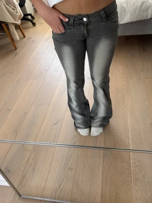Grå bootcut jeans med låg midja - Snygga grå bootcut jeans med låg midja från Weekday. Jeansen har en lätt tvättad look och är i stretchigt denimtyg och släpper ut vid benen. Perfekta för en trendig och avslappnad stil! Priset kan diskuteras