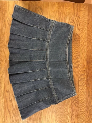 Supersnygg mörkblå plisserad jeanskjol - Säljer denna snygga mörkblå jeanskjol med plisserad design då den är för stor för mig😊inga defekter och bra skick! Storlek S eller 36