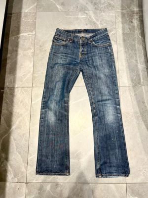 Nudie jeans Bootcut ola - Säljer dessa riktigt feta Nudie Bootcut ola med en skön fade. Dom är i väldigt bra skick och är k storlek 29/32, det sitter mer som w28! Skriv vid minsta fråga/fundering🙌🏼 Midja: 37,5 cm Längd: 101 cm Benöppning: 20 cm