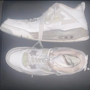 Jordan 4 Oreo - • Det finns tydliga creases (veck) över tåboxen. • Insidan/fodret har lite noppor efter användning. • Sulan är smutsig men har fortfarande mönster kvar. • Jumpman-loggorna på häl och tunga är intakta