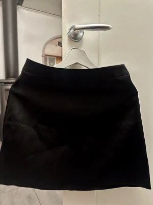OANVÄND minikjol i satin - Säljer en svart minikjol från gina i storlek 36. Superfin lyster, mjukt material och sitter snyggt på. Perfekt till fest, middag eller en vardagsoutfit. Helt ny, med prislapp där ordinarie pris ligger på 399,95 kr