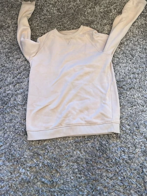 Beige sweatshirt från Primark - En enkel och stilren beige sweatshirt från Primark i storlek 158 cm. Tröjan har rund halsringning, ribbade muddar vid ärmslut och nederkant samt mjuk insida. Perfekt för en avslappnad look.