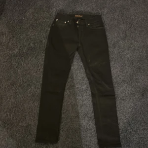 Svarta skinny jeans från BLK DNM - Säljer ett par svarta jeans från BLK DNM med klassisk femficksmodell och knappgylf. Jeansen har en smal passform och raka ben, perfekta till en streetwear-look. Materialet är stretchigt för extra komfort.