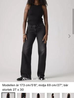 Svarta low loose jeans från Levi’s - Säljer ett par svarta, vida jeans från Levi’s med låg midja och vida ben. Jeansen har klassisk femficksdesign och är tillverkade i denim med lätt tvättad look. Perfekta för en avslappnad och trendig stil. Använd ett par gånger, säljer nu för de inte passar längre. Bra skick.