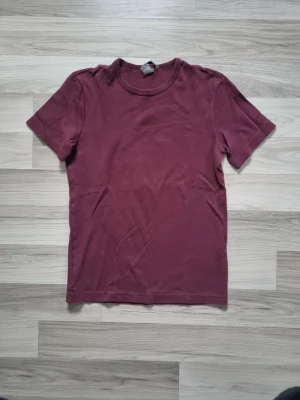 Vinröd basic t-shirt i bomull - Enkel och stilren vinröd t-shirt i mjuk bomull. Klassisk rund halsringning och korta ärmar. Perfekt till jeans eller shorts för en avslappnad look.