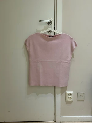  Ny Ljusrosa ärmlös topp - En enkel och stilren ljusrosa topp med rak passform och ärmlös design. Toppen har en mjuk känsla och passar perfekt till jeans eller kjol. Inga synliga detaljer eller mönster, bara clean och snygg look.