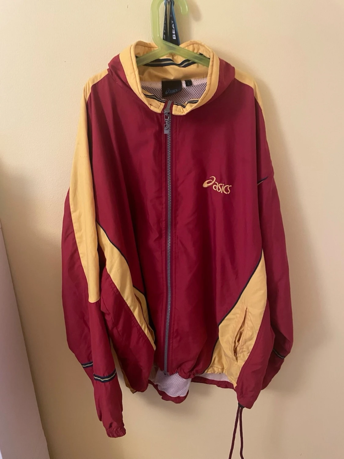 Röd och gul vindjacka från Asics