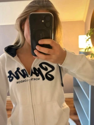 Vit Spurs hoodie med dragkedja - Snygg vit hoodie med dragkedja från tottenham. Stor blå logga framtill och liten Tottenham-logga på ärmen. Huva med blå snören och fickor framtill. 