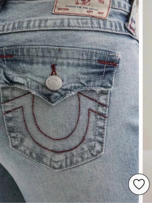 True Religion ljusblå bootcut jeans - Säljer ett par ljusblå bootcut jeans från True Religion med ikoniska röda sömmar och ficklock bak. De är i storleken 26. sparsamt använda så mycket bra skick 💕 skriv för mer bilder/frågor☺️ pris kan absolut diskuteras!! 