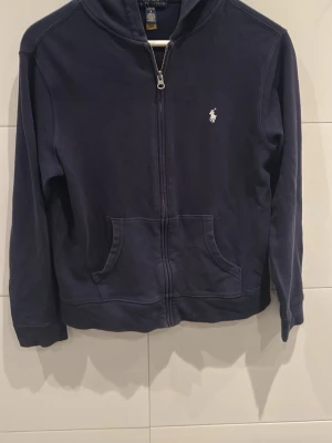Mörkblå hoodie från Polo Ralph Lauren - Hej! Säljer nu en väldigt snygg Ralph lauren zip hoodie i Storlek S. Väldigt populär och trendig. Perfekt nu inför våren och sommaren