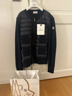 Mörkblå cardigan från Moncler - Mörkblå moncler cardigan i nyskick med prislapp. Storlek S, nypris 9500kr. Skriv för fler bilder och frågor. Finns möjlighet att diskutera pris. Möts helst upp och kan göra det i typ hela Stockholm, men skriv om möjlighet inte finns så går det nog att lösa på andra sätt 