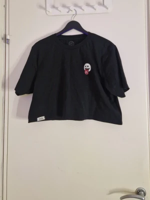 Louis Tomlinson merch - Priset är förhandlingsbart!!! Croppad svart tshirt med ett smiley face från Louis Tomlinsok sommar kollektion 2021. Aldrig använd men är lite luddig. Storlek L.