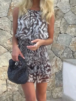 Zara klänning  - Säljer en snygg kort klänning från Zara med brunt och vitt abstrakt mönster. Klänningen har smala axelband, rynkad midja och volang nertill. Lätt och luftig modell, perfekt för varma dagar.