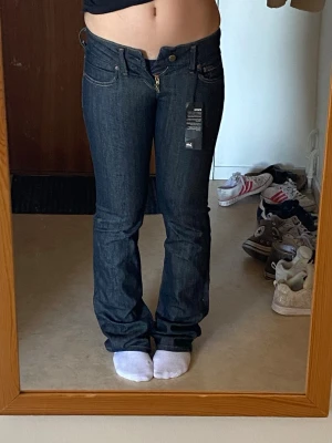 Helt nya mörkblå lågmidjade Lee jeans - Mörkblå/svarta. midjan rakt över:34cm innerben:85cm