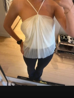 Vit plisserad halterneck linnetopp - Snygg vit plisserad linnetopp med halterneck och tunna axelband. Toppen har en luftig och flowy passform, perfekt för varma dagar. Stilren och enkel att matcha med olika outfits. Hör av er vid frågor eller mer bilder 💗