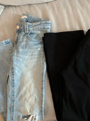 Jeanspaket st 164 - Två par jeans st 164. Ett par svarta från Lindex, Freja. Ett par ljusa från Gina Tricot. Inte mycket använda. 