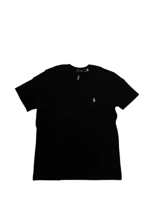 Svart t-shirt från Polo Ralph Lauren - Klassisk svart t-shirt från Polo Ralph Lauren med korta ärmar och rund hals. T-shirten har den ikoniska vita logobroderingen på bröstet och är tillverkad i mjuk bomull för en skön känsla. Perfekt basplagg för en clean och stilren look.