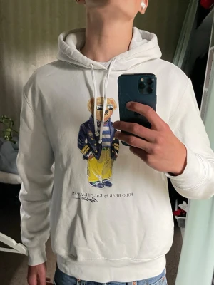 Vit hoodie Polo Bear Ralph Lauren - Tjeneritz, säljer nu denna fina hoodie från ralphlauren, bra skick och funkar perfekt till vardagen. Grabben på bilden är 175 och väger ca 63kg, tveka inte att höra av dig vid minsta fundering