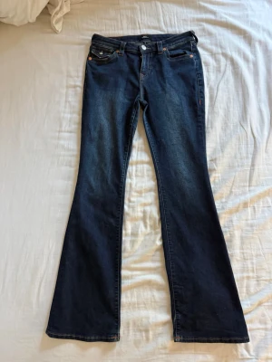 True Religion jeans Becca - Supersnygga jeans från True Religion i modellen Becca mid rise bootcut. Storlek 29 motsvarande M/L. Stretchigt material. Sparsamt använda, mycket fint skick. Inköpta i Januari för 1299kr.