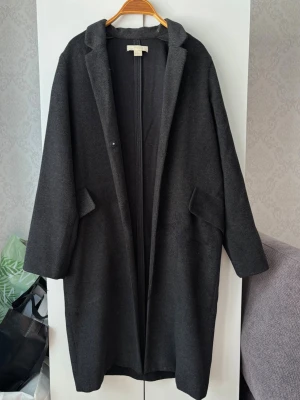 Grå kappa - Stilren grå kappa i rak modell med fickor från H&M i strl 32 men skulle mer säga strl 34 till passformen!❤️