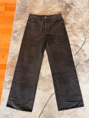 Vuja de Steve shadow - Säljer ett par vuja de jeans med rak passform och hög midja. Jeansen har klassisk femficksdesign och knappgylf. Materialet är kraftig denim i bomull och färgen är tvättad svart för en cool vintagekänsla.