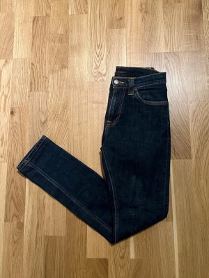 Nudie Jeans - W27/L30 - Nudie Jeans för män till salu. Plagget är nyskick inga skador/slitage. Storlek Waist 27 / Lenght 30. Hör av dig vid intresse/frågor. PRIS KAN DISKUTERAS!